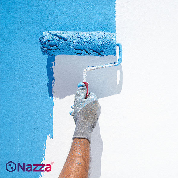 Aplicación de pintura azul con rodillo sobre una pared blanca, mostrando la importancia de repartir bien el producto para evitar marcas, cortes y diferencias de cobertura.